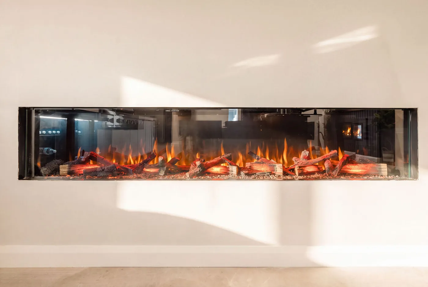 Wide linear fireplace photographed straight on with the flames lit