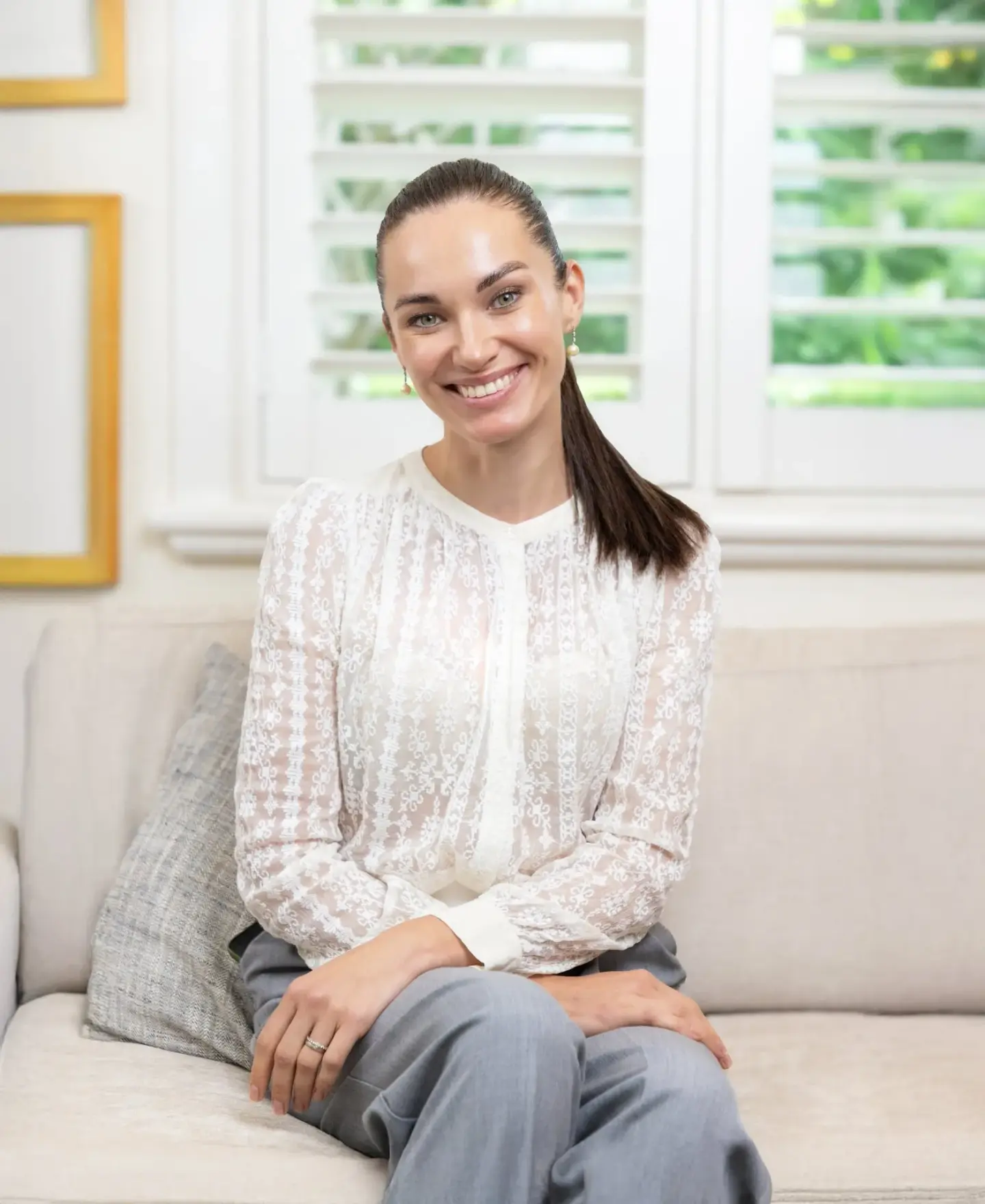 Natural-light business portrait of a smiling professional on a sofa