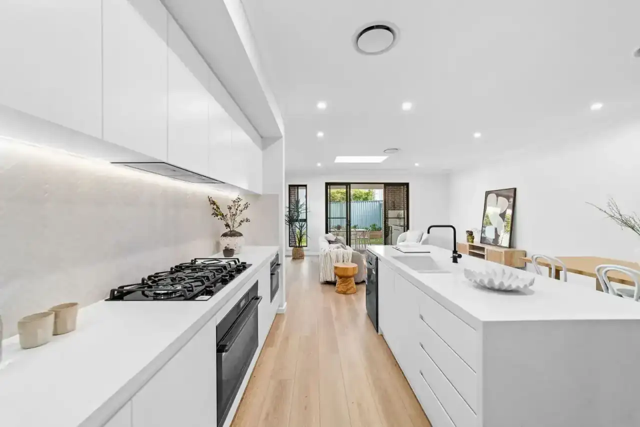 Open-plan kitchen and living area with island bench and timber floors